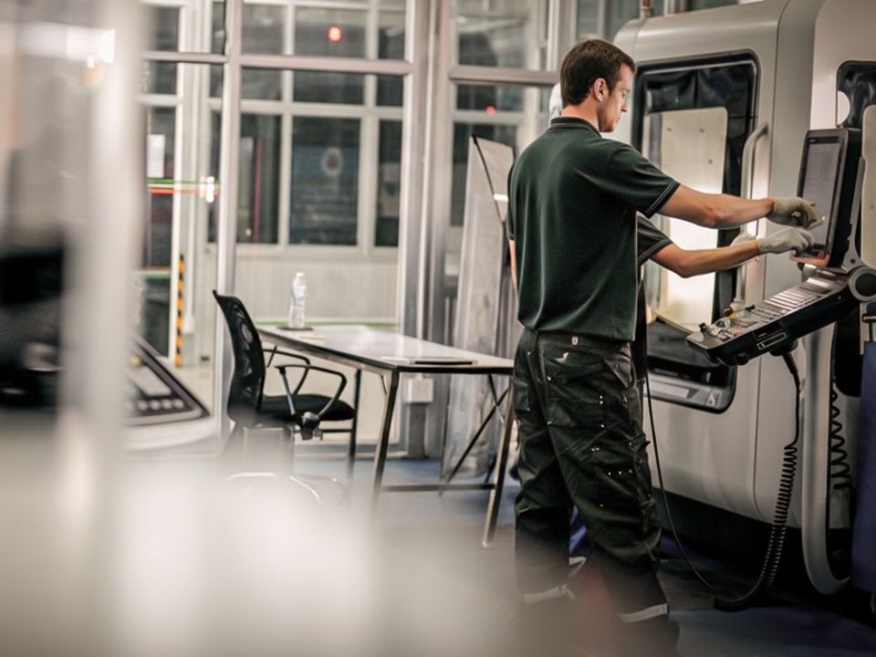 Mitarbeiter an einer Maschine in der Fertigung